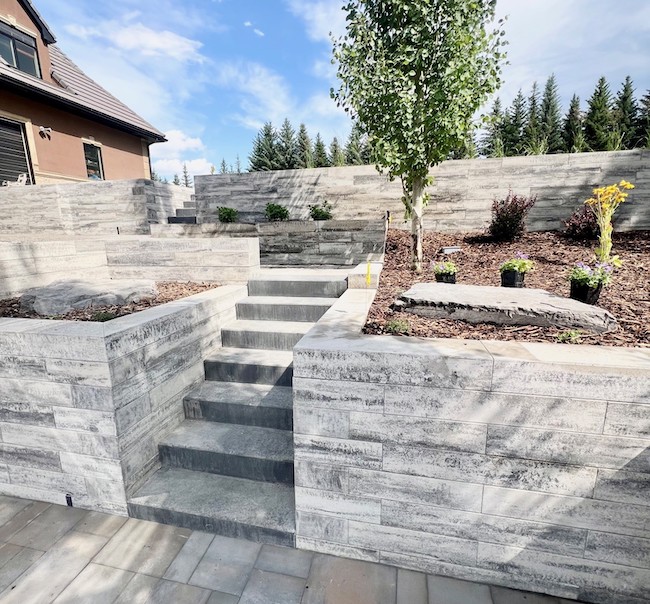 Stone retaining wall built into a sloped Calgary yard